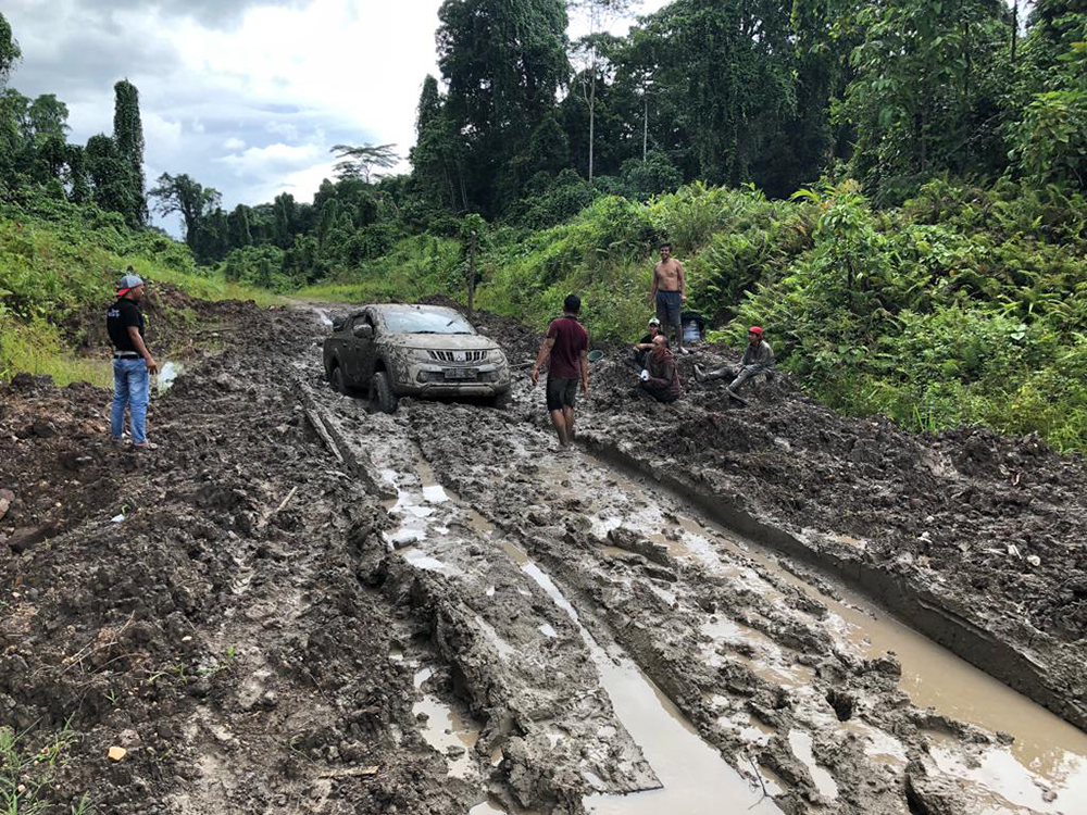 A car stuck on a muddy road on Klaso. It supposes a red-colored car until mud cover it.